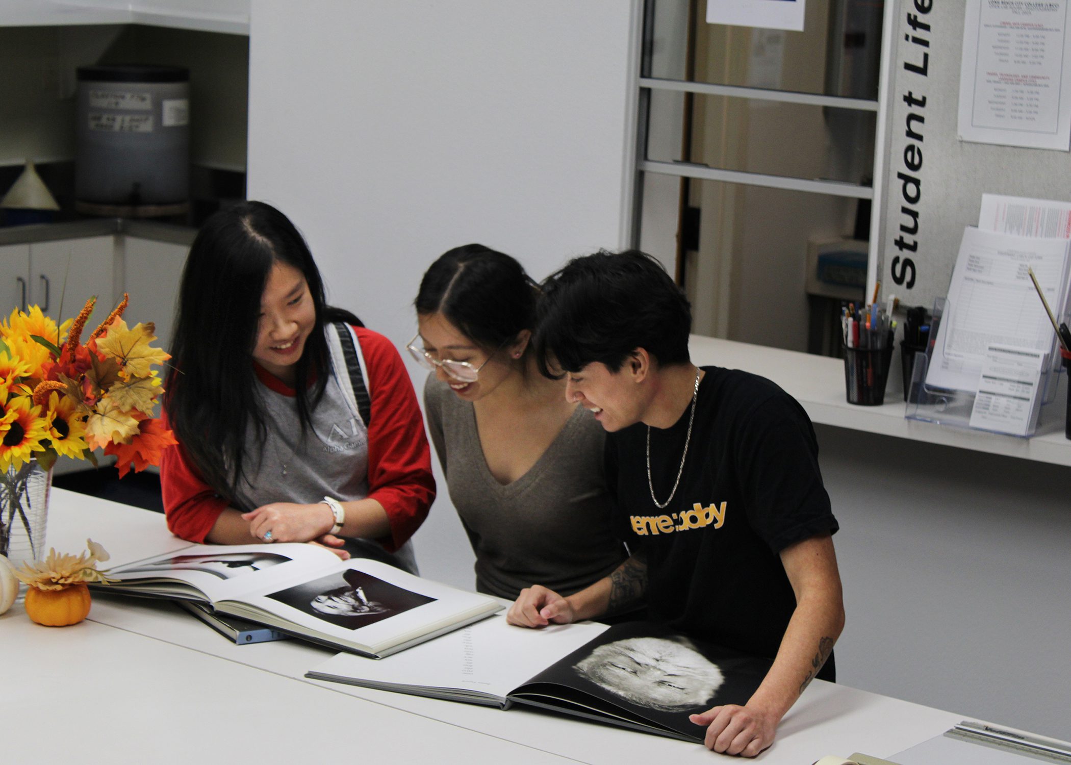 Tien Nguyen shows her classmates a portrait of Van Cao by Peter Steinhauer at the Photography Lab, Long Beach City College, 09.2025. Photo: Brian Doan.
